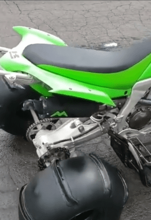 Green ATV with large black tires.